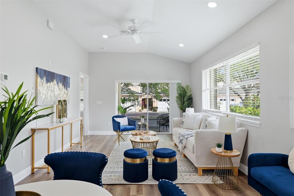 A living room features a white sofa, blue accent chairs, and a sliding glass door — 503 AUBURN COVE CIRCLE, VENICE, FL