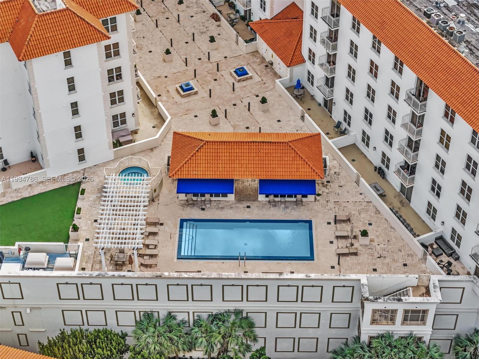 An aerial view shows a swimming pool, a hot tub, and a patio between buildings — 2030 S Douglas Rd # 109, Coral Gables FL 33134, CORAL GABLES, FL