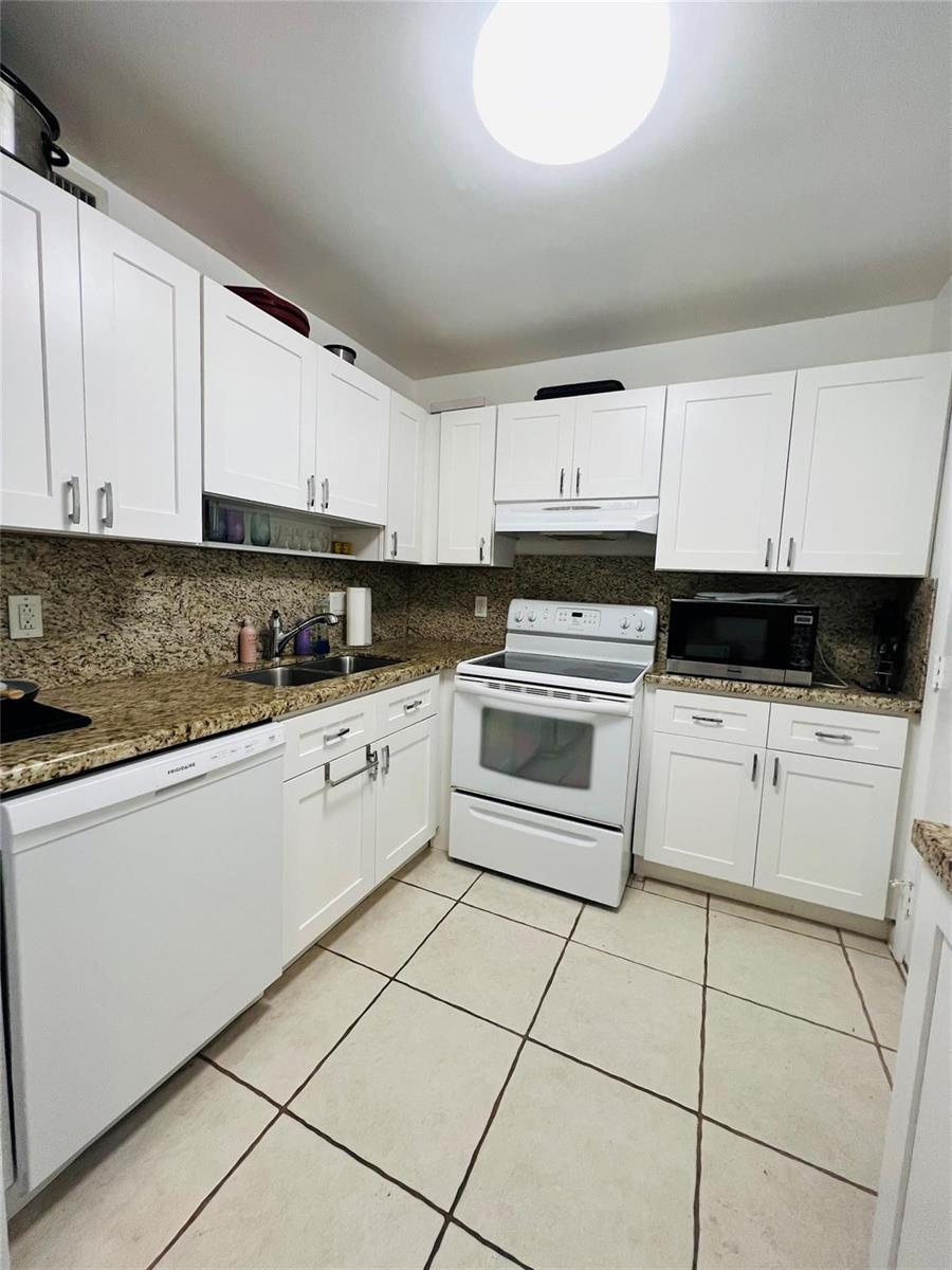 A kitchen features white cabinets, granite countertops, white appliances, and light-colored tile flooring — 4040 N Hills Drive # 7, Hollywood FL 33021, HOLLYWOOD, FL