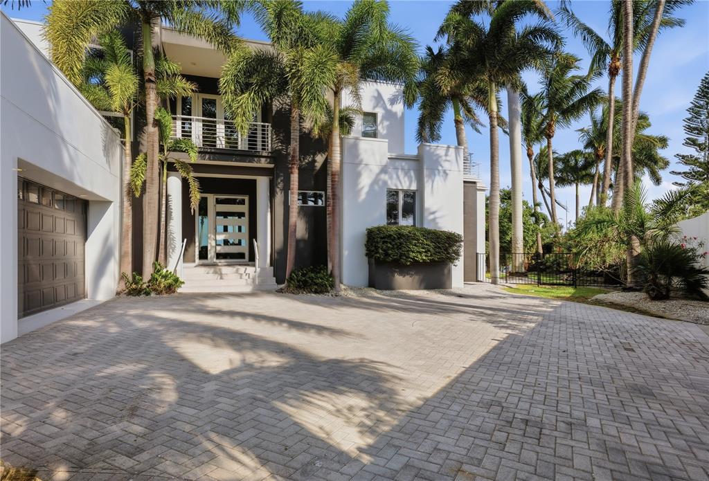 A modern two-story house features a paved driveway, palm trees, and a dark-framed entryway — 1475 JOHN RINGLING PARKWAY, SARASOTA, FL