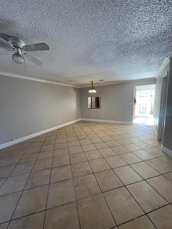 A living room with light gray walls, a ceiling fan, and beige tile flooring — 6218 YORKTOWN DRIVE UNIT 15, ORLANDO, FL