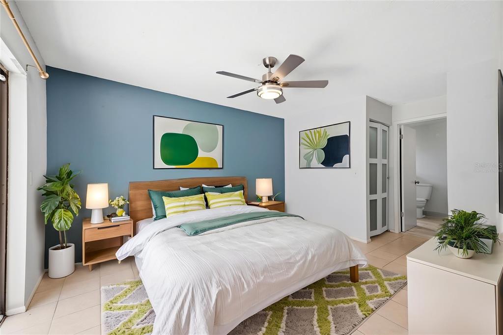 A bedroom features a blue accent wall, a wooden bed frame, and a ceiling fan — 8178 ENGLISH ELM CIRCLE, SPRING HILL, FL