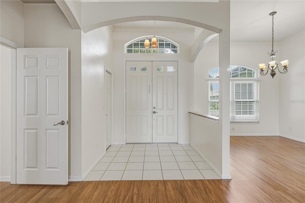 An entryway with white tile flooring, a double front door, and wood-look laminate flooring — 6305 ROCK CREEK CIRCLE, ELLENTON, FL