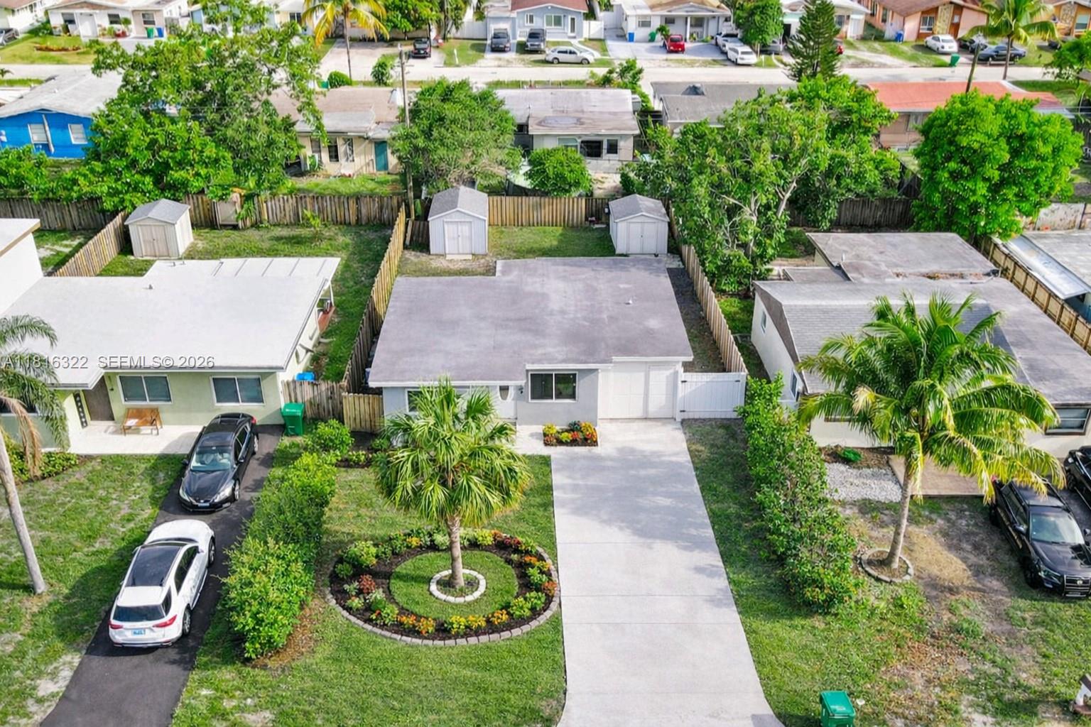 An aerial view shows a single-story house with a concrete driveway, palm trees, and sheds — 6336 SW 22nd St, Miramar FL 33023, MIRAMAR, FL