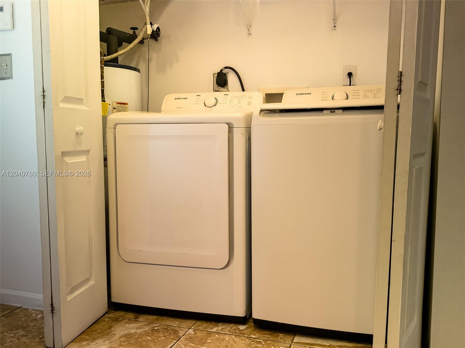 A laundry closet contains a white Samsung washer and dryer next to a water heater — 19251 NW 33rd Ave, Miami Gardens FL 33056, MIAMI GARDENS, FL