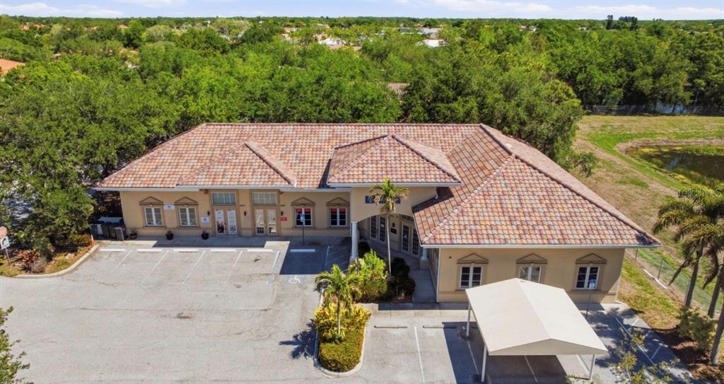 An aerial view of a single-story commercial building with a tiled roof and parking lot — 5275 OFFICE PARK BOULEVARD, BRADENTON, FL