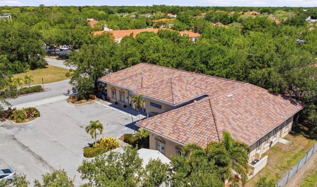 An aerial view of a single-story commercial building with a tiled roof and parking lot — 5275 OFFICE PARK BOULEVARD, BRADENTON, FL