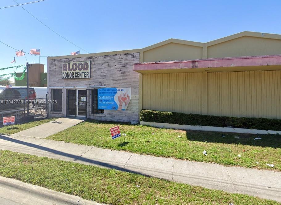 The exterior of a single-story commercial building features a blood donor center sign and signage — 9360 NW 27th Ave, Miami FL 33147, MIAMI, FL