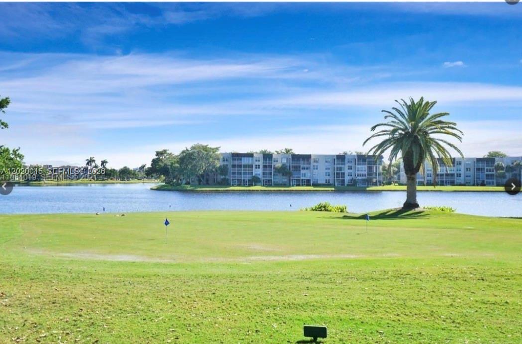 A view of a golf course green overlooking a lake and multi-story apartment buildings — 9480 Tangerine Pl # 404, Davie FL 33324, DAVIE, FL
