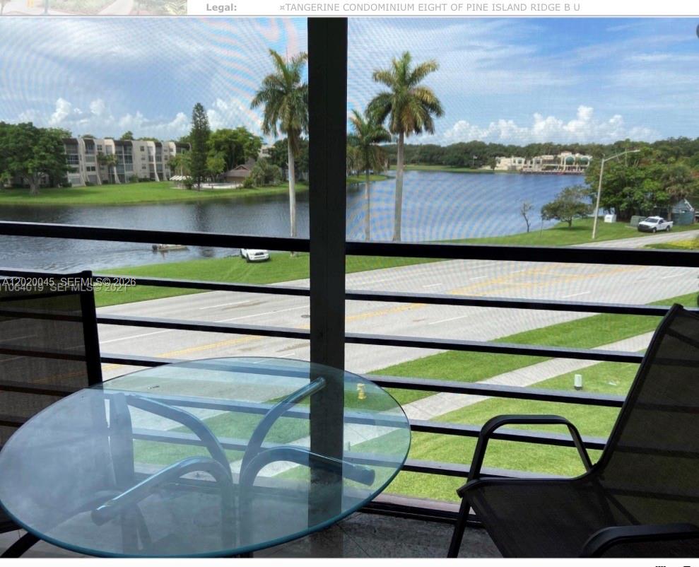 A view of a lake and palm trees from a screened-in balcony with patio furniture — 9480 Tangerine Pl # 404, Davie FL 33324, DAVIE, FL
