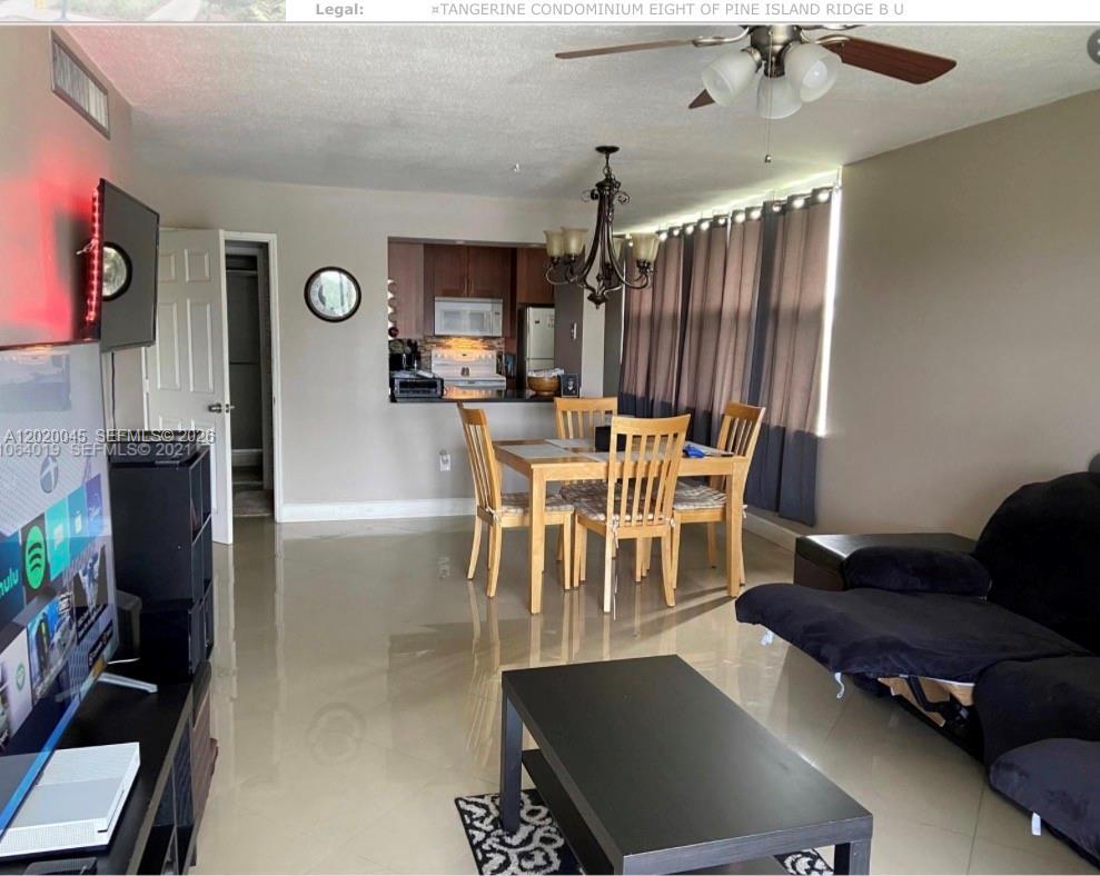 A living room and dining area with tile floors, a ceiling fan, and an open kitchen — 9480 Tangerine Pl # 404, Davie FL 33324, DAVIE, FL
