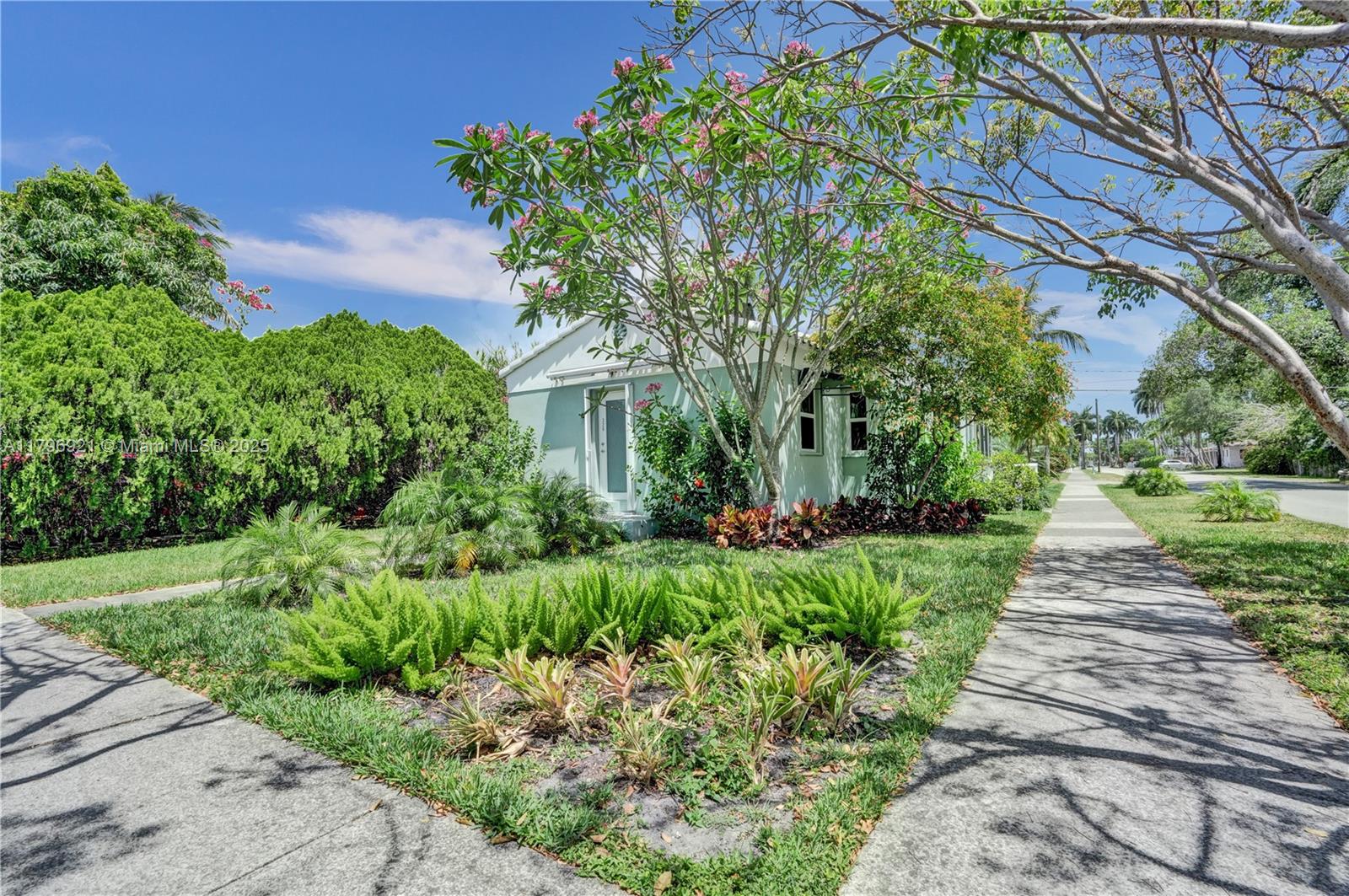 A light green house with a front garden and sidewalk under a clear blue sky — 326 S 14th Ave, Hollywood FL 33020, HOLLYWOOD, FL