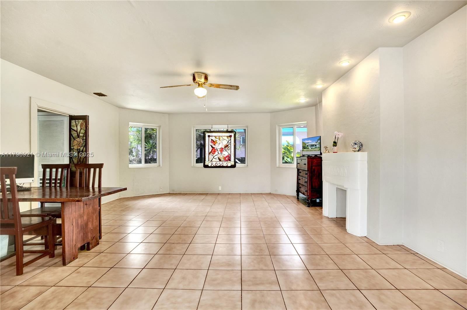 A dining area with tile floors, a ceiling fan, and a decorative fireplace — 326 S 14th Ave, Hollywood FL 33020, HOLLYWOOD, FL