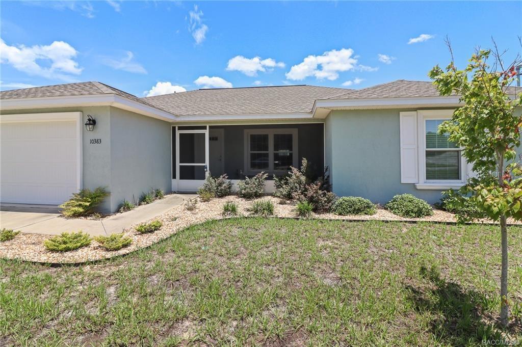 A single-story house with a light green exterior, a garage, and a screened front porch — 10383 N G MARTINELLI BOULEVARD, CITRUS SPRINGS, FL