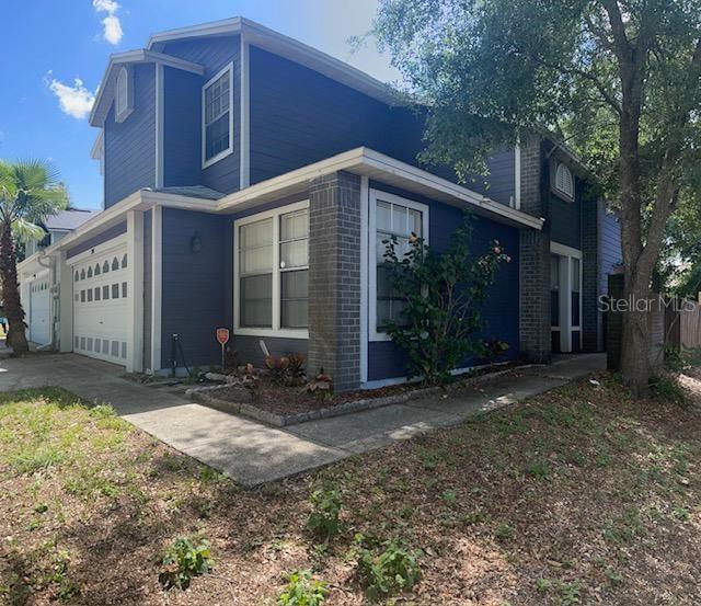 A two-story blue house with a brick accent wall, a garage, and a concrete walkway — 245 ALSTON DRIVE, ORLANDO, FL