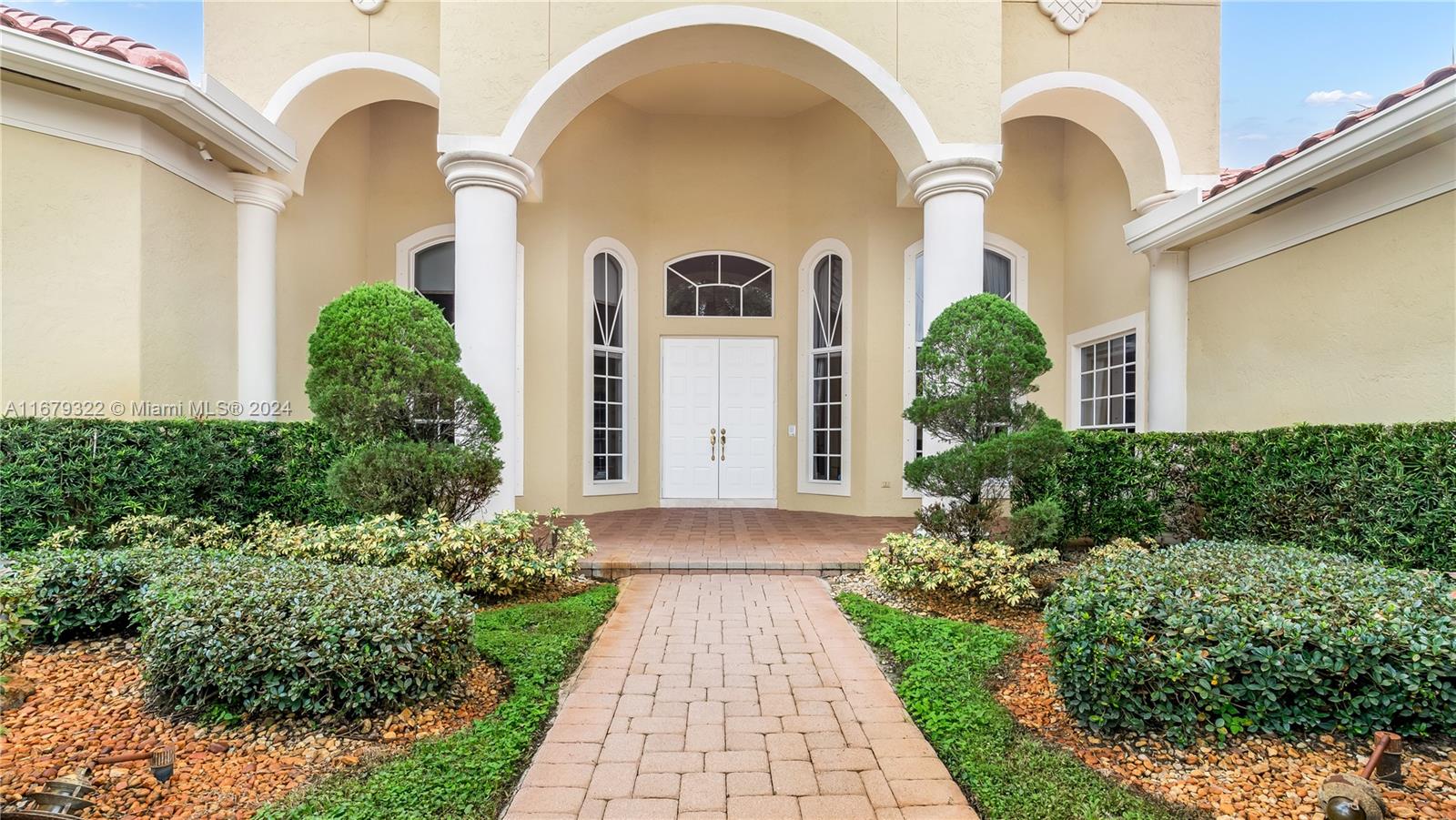 A paved walkway leads to the white double front doors of a house with columns — 12854 Stonebrook Dr, Davie FL 33330, DAVIE, FL