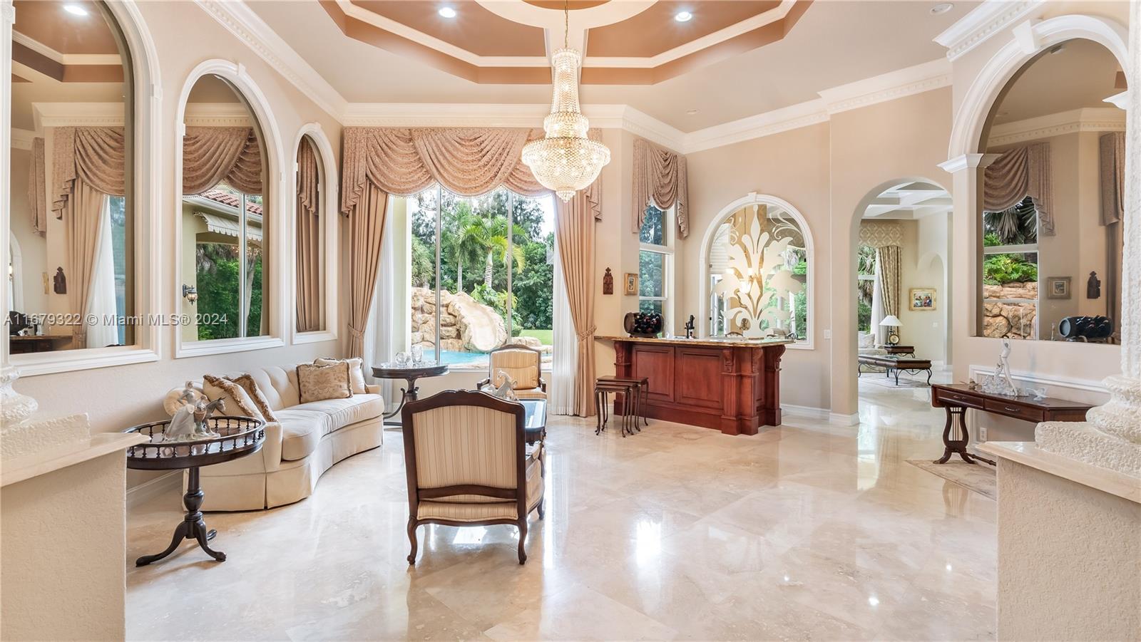 A formal living room features marble floors, a crystal chandelier, and a built-in bar — 12854 Stonebrook Dr, Davie FL 33330, DAVIE, FL