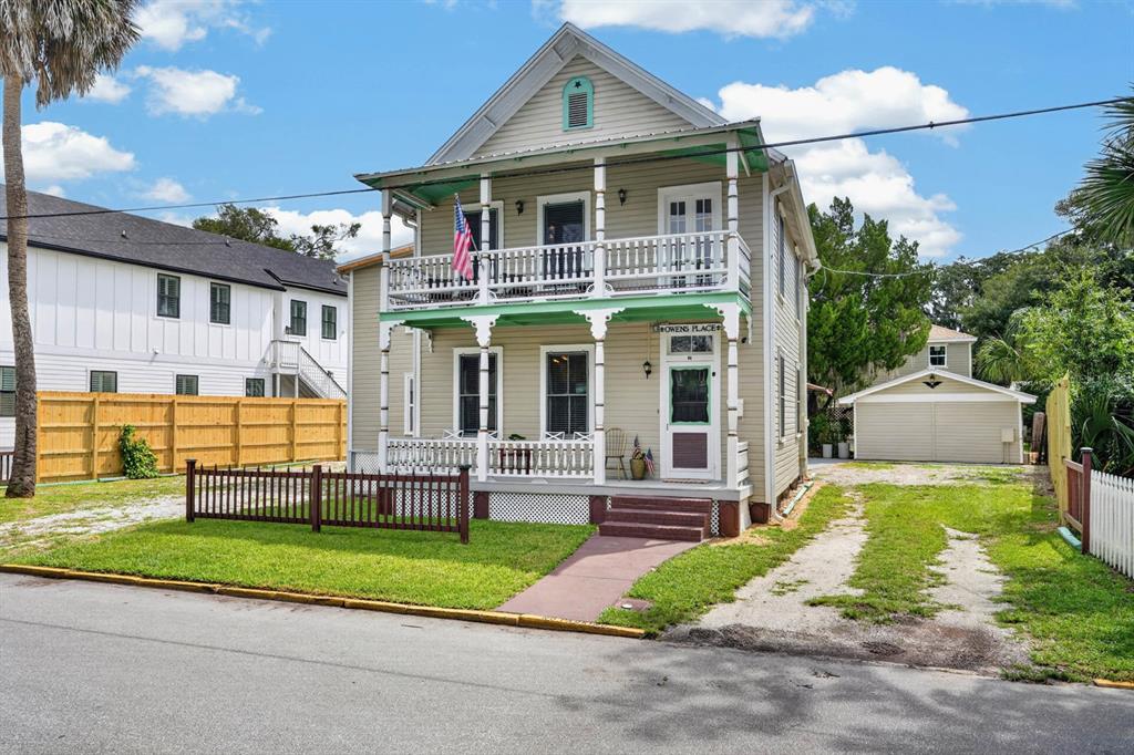 A two-story light-colored house with a front porch, balcony, and detached garage — 31 SANFORD STREET, ST AUGUSTINE, FL
