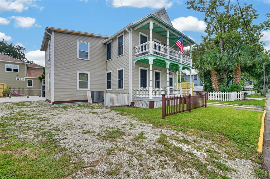 A two-story house with beige siding, a front porch, and a second-story balcony — 31 SANFORD STREET, ST AUGUSTINE, FL