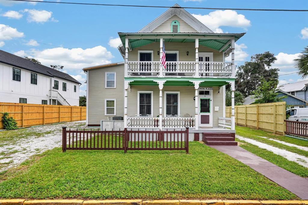 A two-story house with a front porch, balcony, and a brown picket fence — 31 SANFORD STREET, ST AUGUSTINE, FL