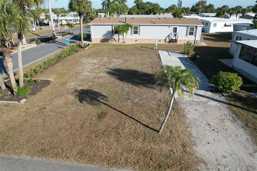 An aerial view of a vacant residential lot with a paved driveway and palm trees — 2100 KINGS HIGHWAY UNIT 28, PORT CHARLOTTE, FL