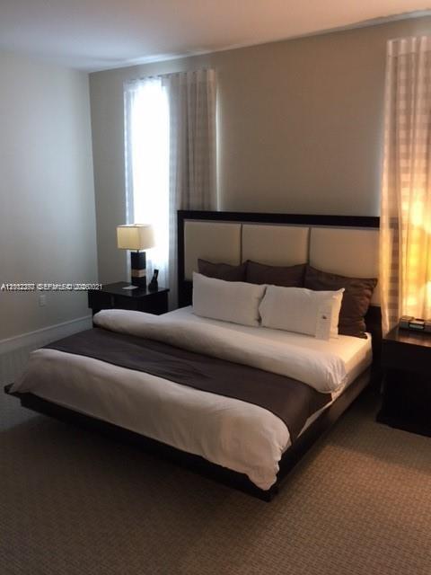 A bedroom features a platform bed with a white headboard and dark brown bedding — 5300 NW 87th Ave # 809, Doral FL 33178, DORAL, FL
