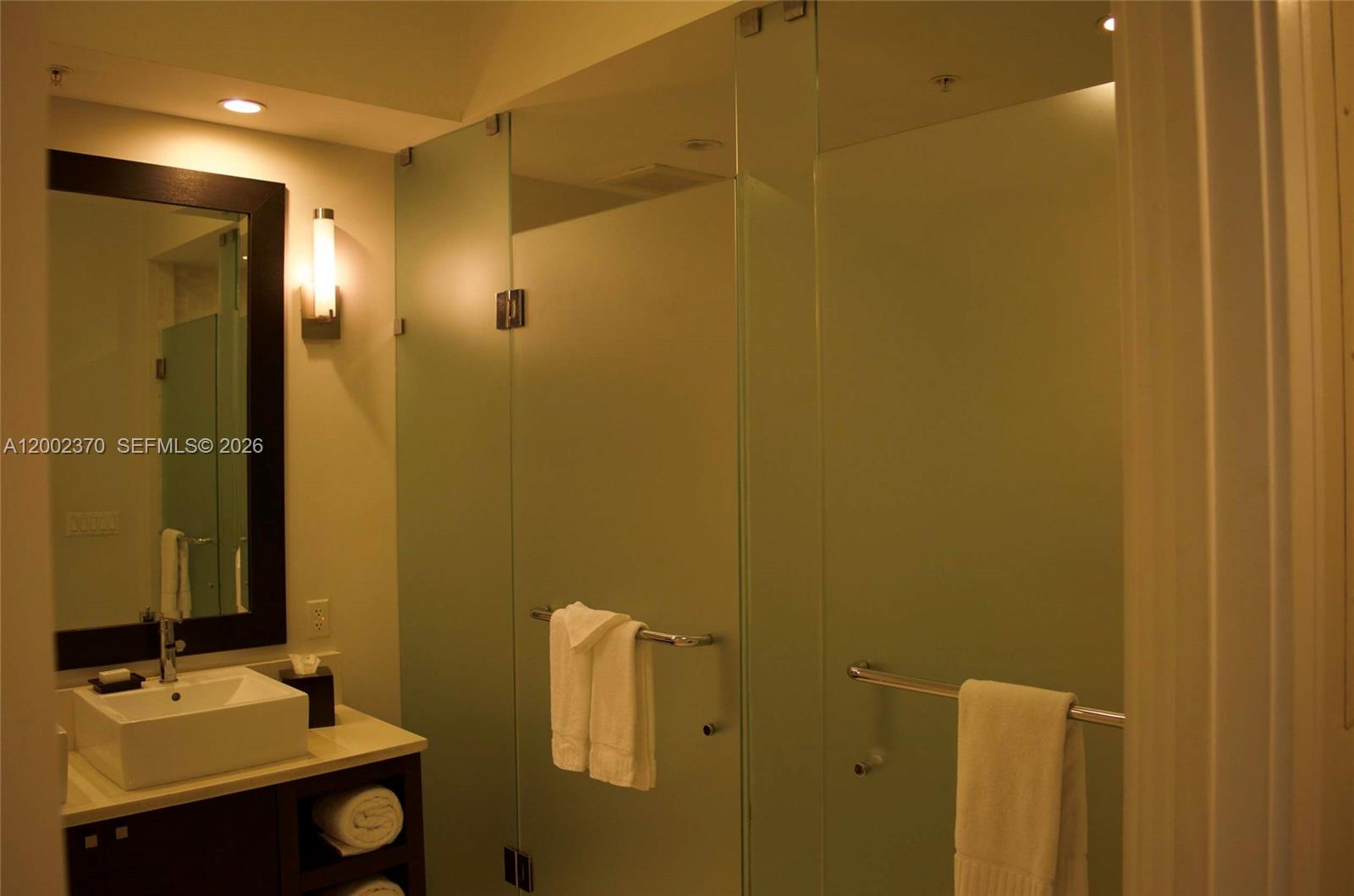 A bathroom features a vessel sink vanity, a dark-framed mirror, and frosted glass shower panels — 5300 NW 87th Ave # 809, Doral FL 33178, DORAL, FL