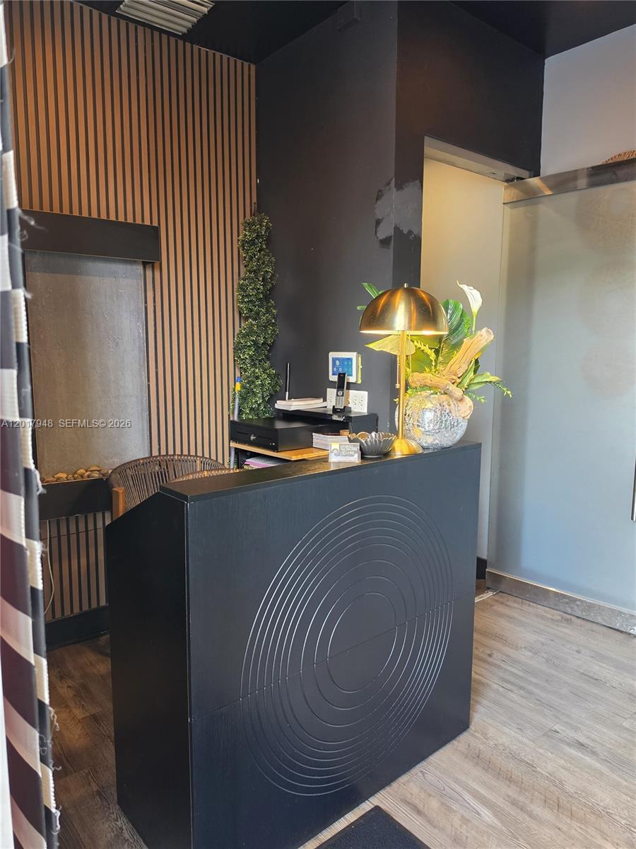 A black reception desk sits in a room with wood-slat wall paneling and a water feature — 15750 SW 56 ST, Miami FL 33185, MIAMI, FL