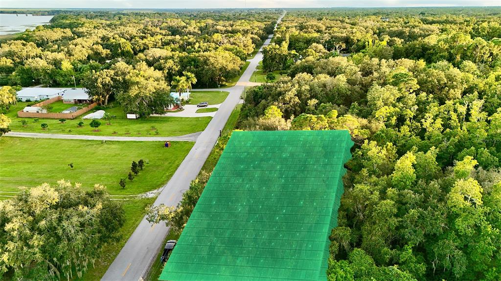 An aerial view shows a green-highlighted plot of land next to a road and trees — 1514 BLACKWILLOW STREET, LAKE PLACID, FL
