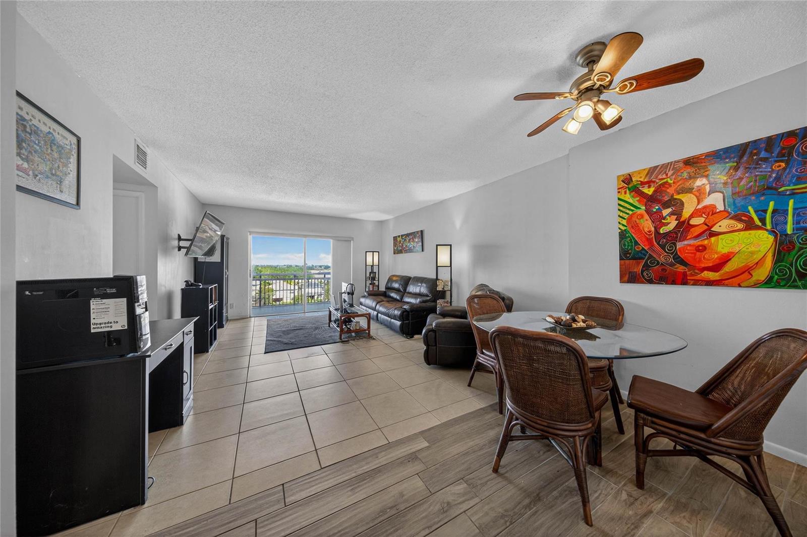 A living and dining area with tile floors, a ceiling fan, and a balcony view — 4400 Hillcrest Drive # 704, Hollywood FL 33021, HOLLYWOOD, FL