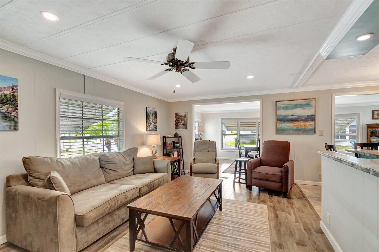 A living room features a beige sofa, wooden coffee table, two armchairs, and wood-look flooring — 14001 Kingston Bay, Boynton Beach FL 33436, BOYNTON BEACH, FL