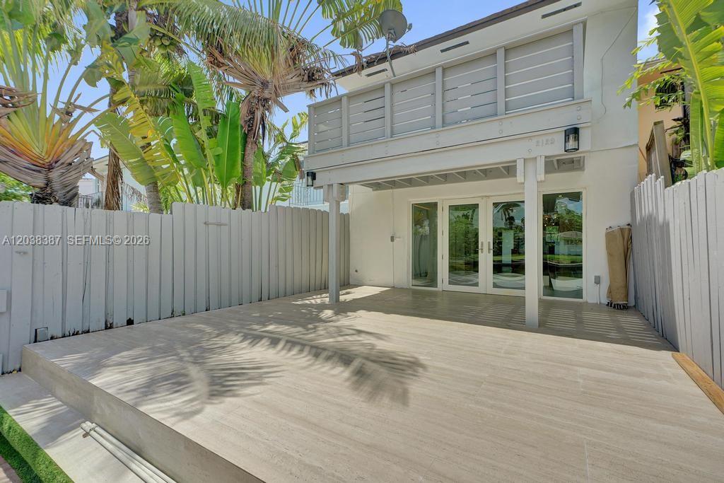 A paved patio sits in front of a two-story house with a wooden balcony — 2129 NE 123rd St # 0, North Miami FL 33181, NORTH MIAMI, FL