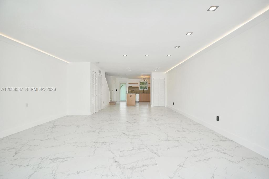 A bright, open-concept living area features white marble-look tile flooring and recessed ceiling lighting — 2129 NE 123rd St # 0, North Miami FL 33181, NORTH MIAMI, FL