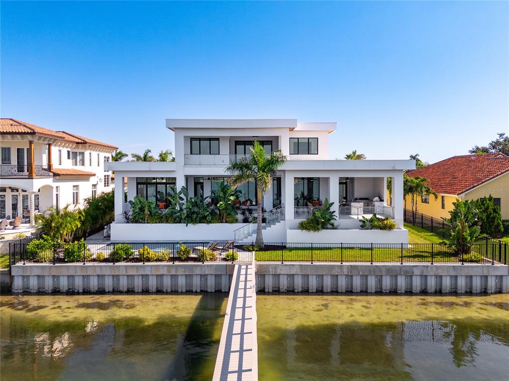 A modern white waterfront house features a pool, a palm tree, and a wooden dock — 5237 61ST AVENUE S, ST PETERSBURG, FL