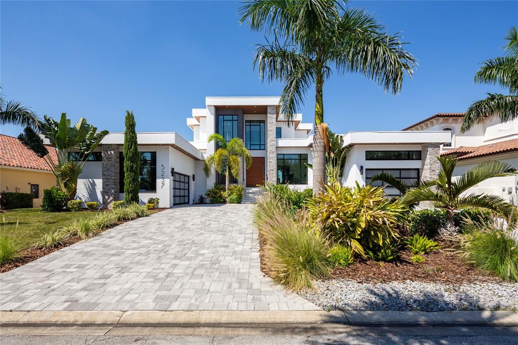 A modern two-story house with a paved driveway, palm trees, and white exterior walls — 5237 61ST AVENUE S, ST PETERSBURG, FL