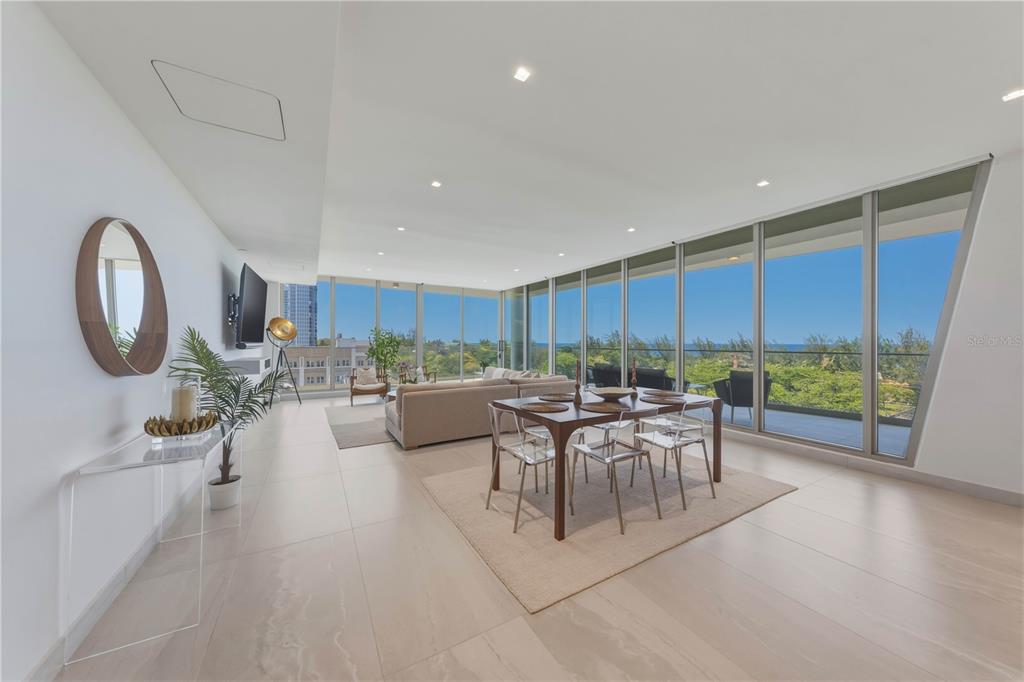 A modern living and dining area features floor-to-ceiling windows with ocean views and tile flooring — 540 AVE. DE LA CONSTITUCION UNIT 801, SAN JUAN, PR