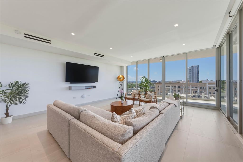 A modern living room features a large sectional sofa, wall-mounted television, and floor-to-ceiling windows — 540 AVE. DE LA CONSTITUCION UNIT 801, SAN JUAN, PR