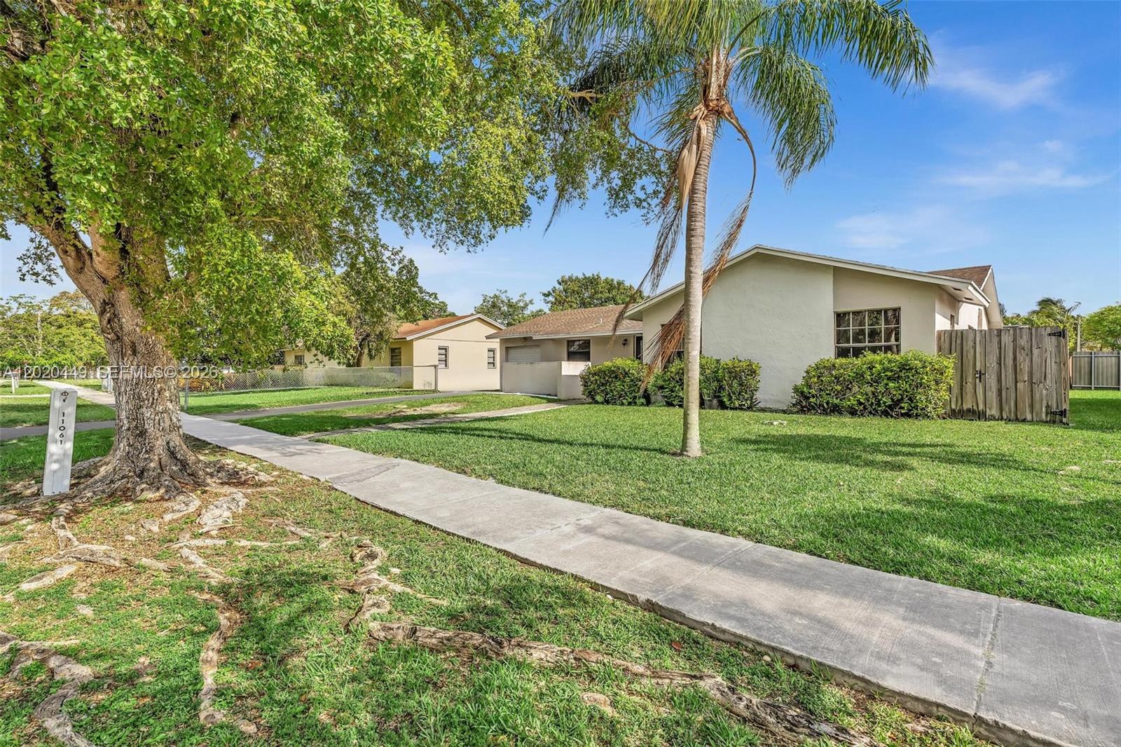 A single-story house with a palm tree and a large tree in the front yard — 11061 SW 163rd St, Miami FL 33157, MIAMI, FL