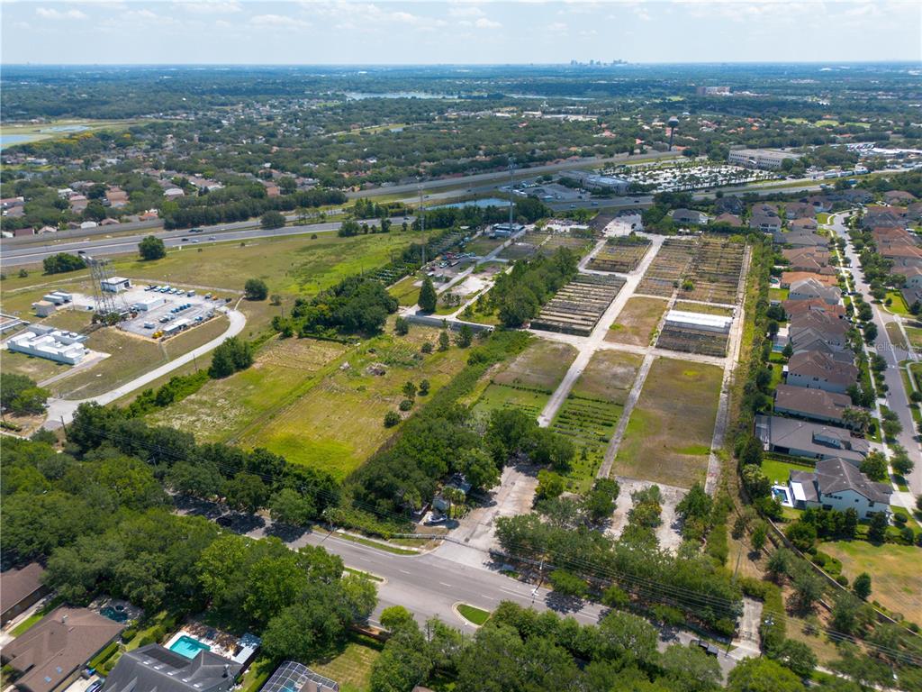 An aerial view shows a large plot of land with a nursery and nearby residential houses — 1955 S APOPKA VINELAND ROAD, ORLANDO, FL
