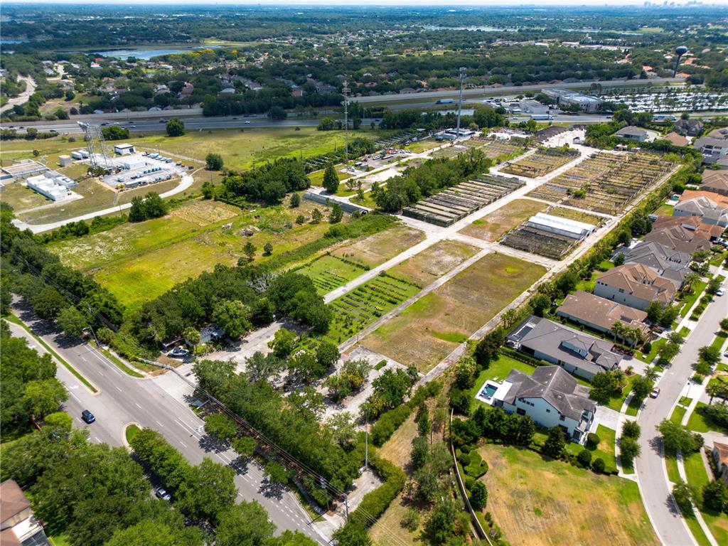 An aerial view shows a large plot of land with agricultural rows and adjacent houses — 1955 S APOPKA VINELAND ROAD, ORLANDO, FL