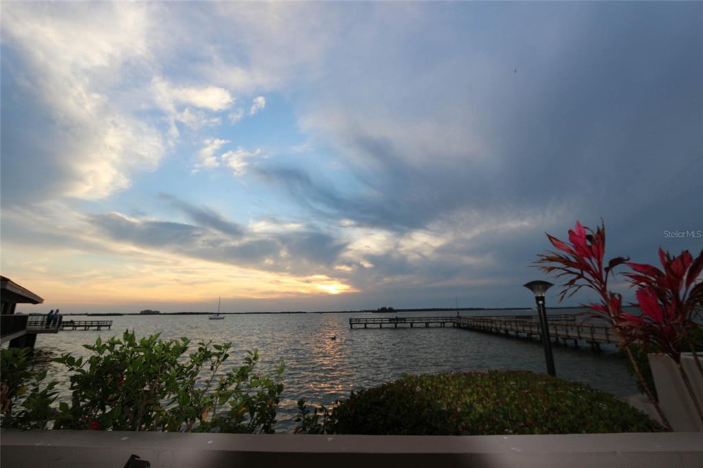 A view of a sunset over a body of water with a wooden pier — 3203 LANDMARK DRIVE UNIT 2202, CLEARWATER, FL