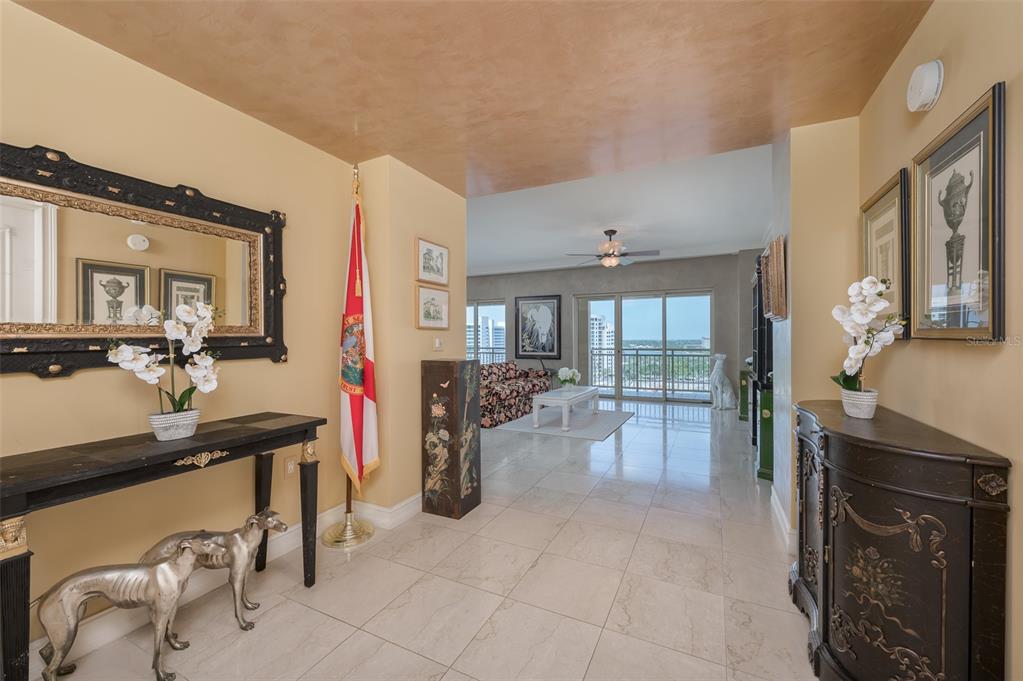 A tiled entryway leads into a living room with a balcony overlooking the water — 1111 RITZ CARLTON DRIVE UNIT 1205, SARASOTA, FL
