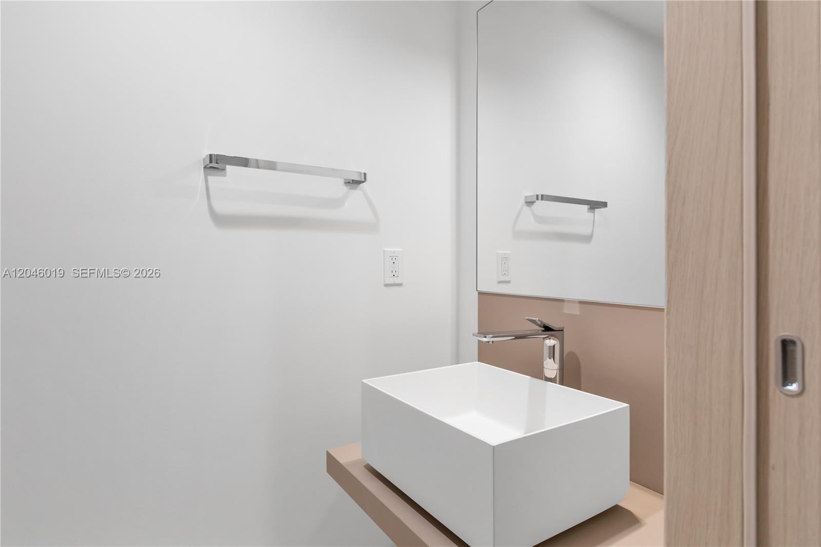 A modern bathroom features a white vessel sink on a tan vanity with a mirror — 1000 Brickell Plz # 4015, Miami FL 33131, MIAMI, FL
