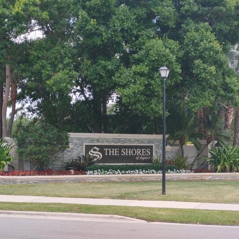 A stone monument sign for The Shores of Jupiter stands in front of lush trees — 6325 Winding Lake Drive, Jupiter FL 33458, JUPITER, FL