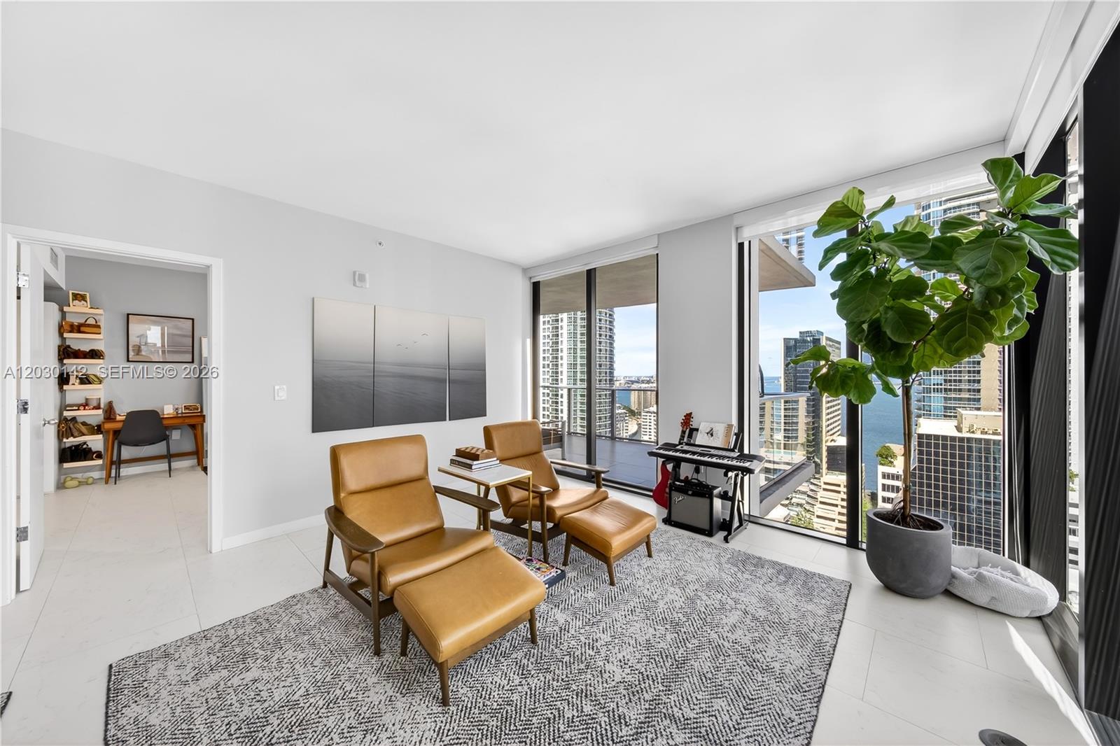 A living area with two leather chairs, a rug, and floor-to-ceiling windows overlooking a city — 1010 Brickell Ave # 2905, Miami FL 33131, MIAMI, FL