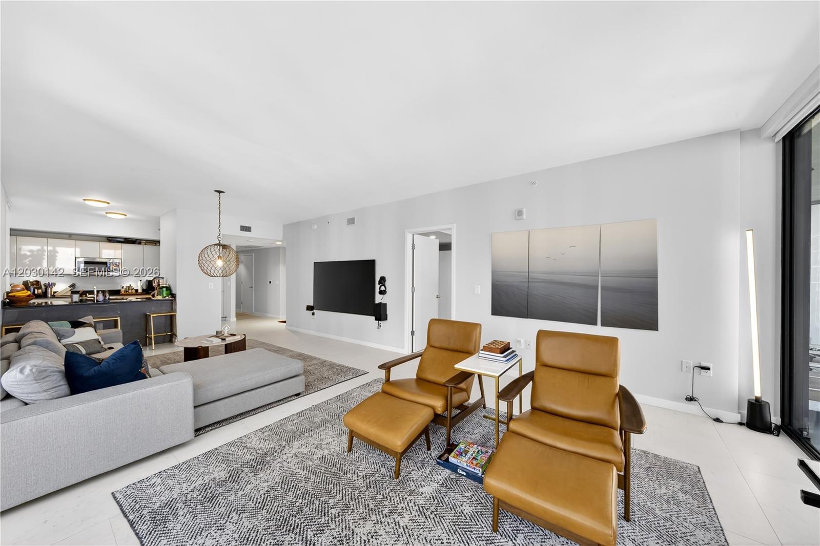 A living room features a grey sectional sofa, two leather armchairs, and a wall-mounted television — 1010 Brickell Ave # 2905, Miami FL 33131, MIAMI, FL