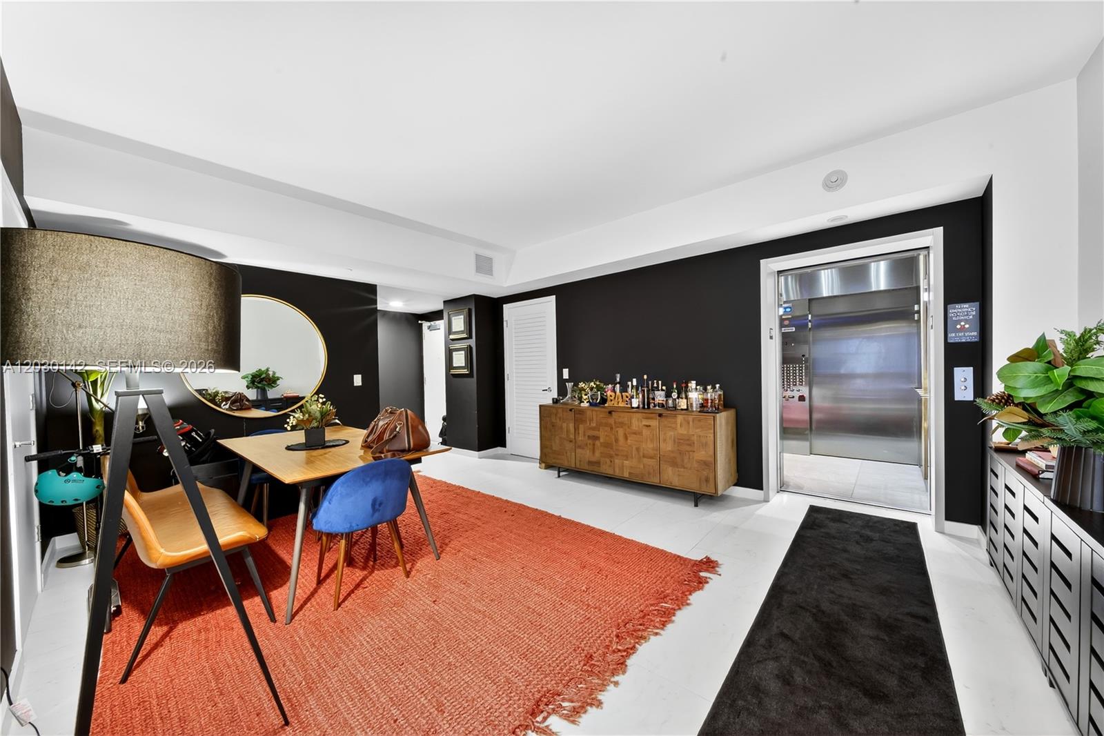 A dining area features a wooden table, blue chairs, a red rug, and a private elevator — 1010 Brickell Ave # 2905, Miami FL 33131, MIAMI, FL