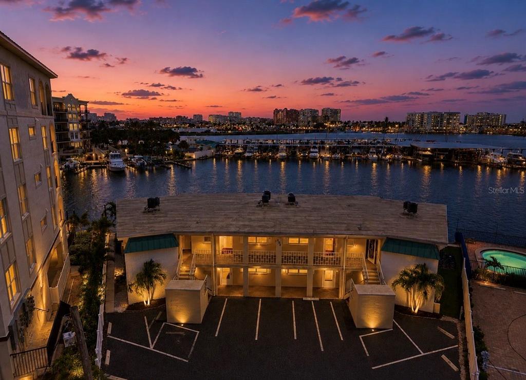 An aerial view of a two-story apartment building with a parking lot at sunset — 205 DOLPHIN POINT UNIT 4, CLEARWATER BEACH, FL