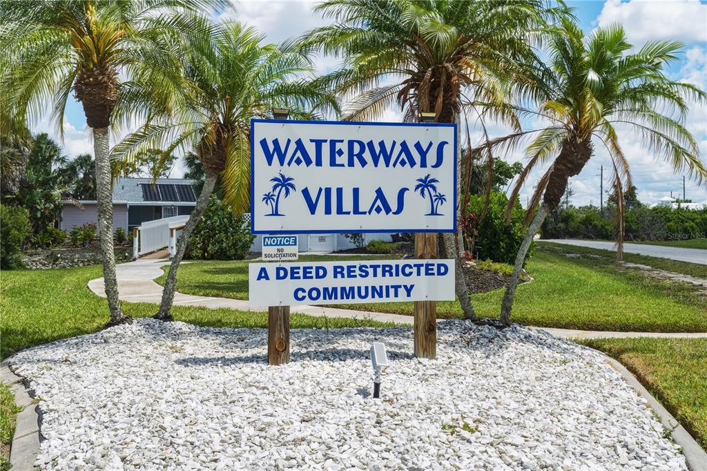 A sign for Waterways Villas stands in a landscaped area with palm trees — 14431 WORTHWHILE ROAD, PORT CHARLOTTE, FL