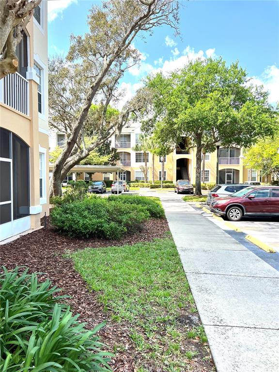 An exterior view shows a multi-story apartment building with a parking lot and landscaping — 6214 STEVENSON DRIVE UNIT 307, ORLANDO, FL